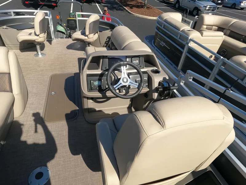 Slide: The Image of 2024 Sun Tracker Fishin' Barge 22 XP3 interior with beige seating and steering console. - 6