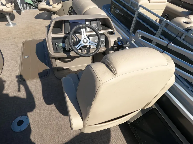 Slide: The Image of 2024 Sun Tracker Fishin' Barge 22 XP3 helm station with beige captain's chair and steering wheel. - 7