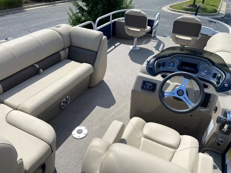 Slide: The Image of 2023 Sun Tracker Fishin' Barge 22 DLX interior with beige seating and modern dashboard. - 6
