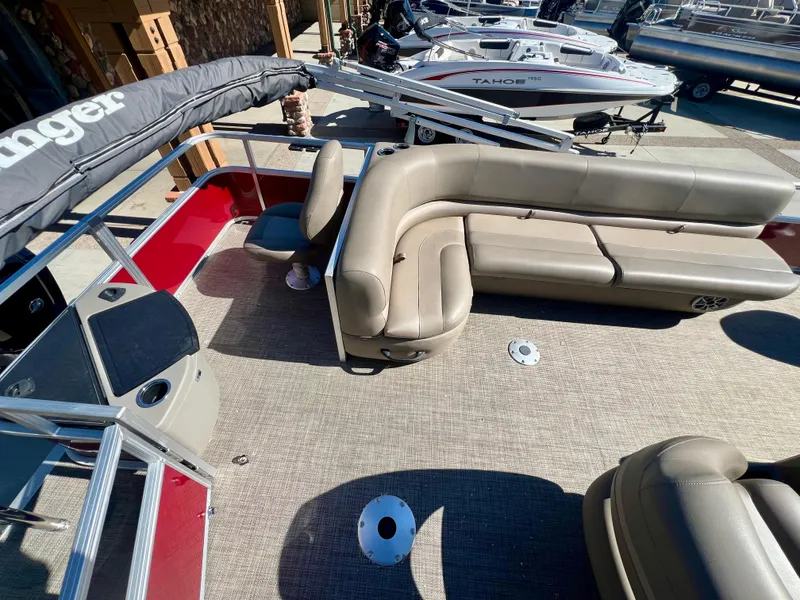 Slide: The Image of 2024 Ranger Reata 200F pontoon boat interior with beige seating and red accents. - 4