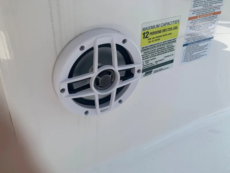 Slide: The Image of Close-up of a speaker and capacity label on a 2022 Robalo R230 boat. - 10