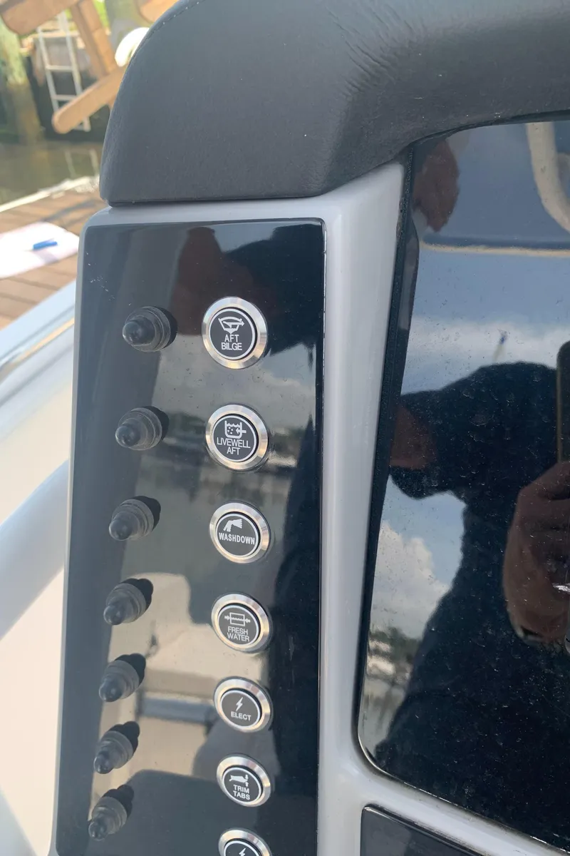 Slide: The Image of Control panel of a 2022 Robalo R230 boat with various switches. - 11