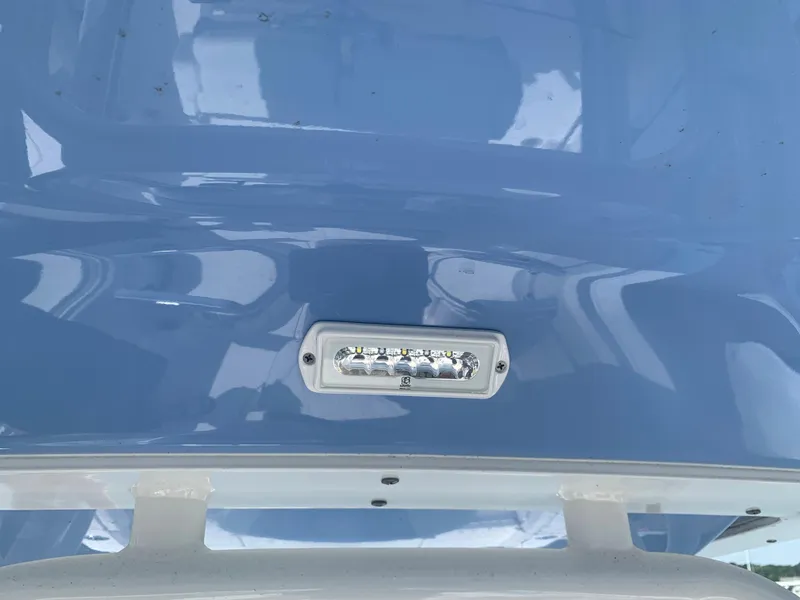 Slide: The Image of 2022 Robalo R230 boat with blue hull and LED light. - 22
