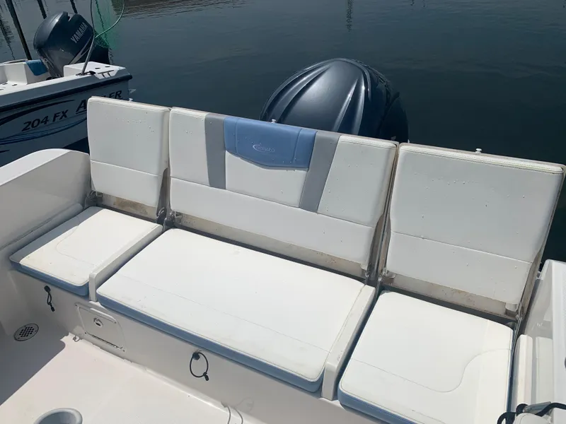 Slide: The Image of 2022 Robalo R230 boat with white cushioned seating and outboard motor. - 23