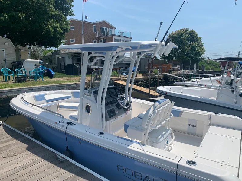 Slide: The Image of 2022 Robalo R230 boat docked at a marina on a sunny day. - 3