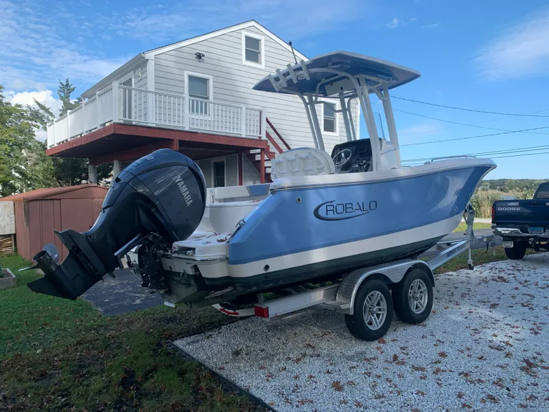 Slide: The Image of 2022 Robalo R230 boat on trailer in front of a house. - 35
