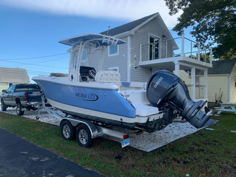 Slide: The Image of 2022 Robalo R230 boat on trailer in front of a house. - 36