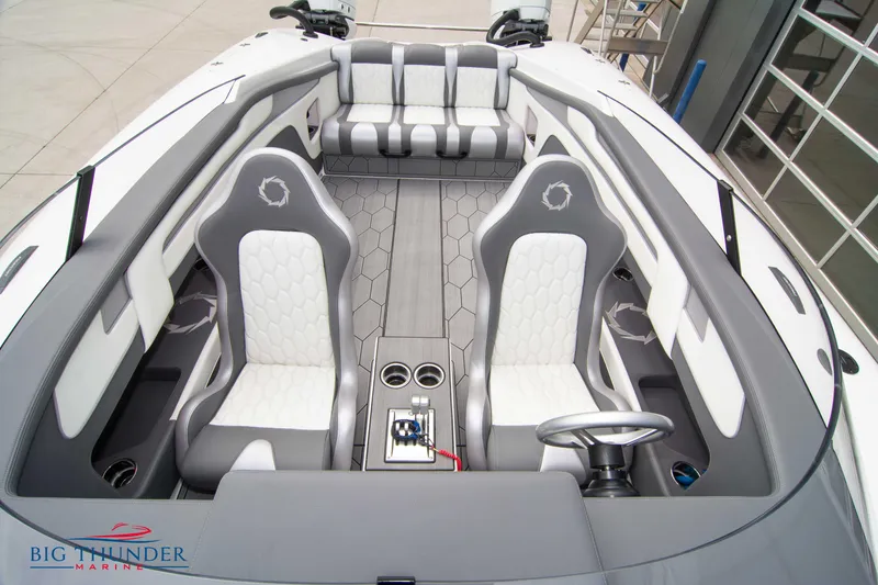 Slide: The Image of 2023 Fountain 34 Thunder Cat interior with grey and white seating, steering wheel, and cup holders. - 13