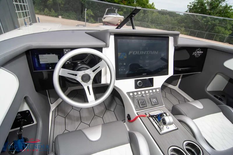 Slide: The Image of 2023 Fountain 34 Thunder Cat boat cockpit with modern steering wheel and touchscreen display. - 22