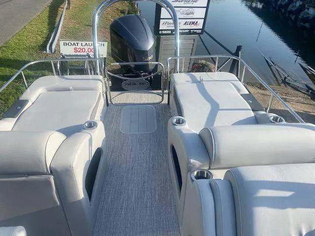 Slide: The Image of 2023 SunCatcher Elite 326 SS pontoon boat interior with plush seating and outboard motor. - 12