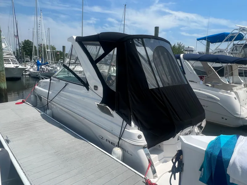 Slide: The Image of 2019 Regal 28 Express boat docked at a marina with black canopy. - 11
