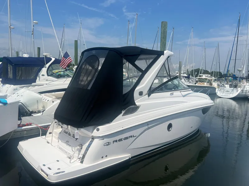 Slide: The Image of 2019 Regal 28 Express boat docked in a marina with other boats. - 14
