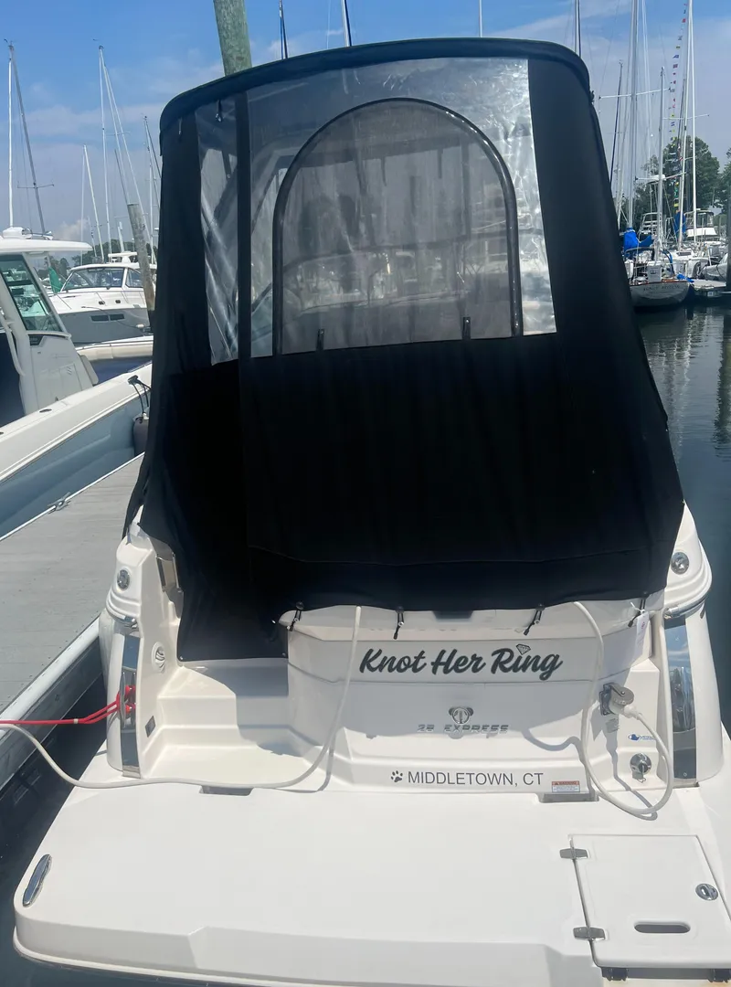 Slide: The Image of 2019 Regal 28 Express boat docked at marina with black canopy. - 16