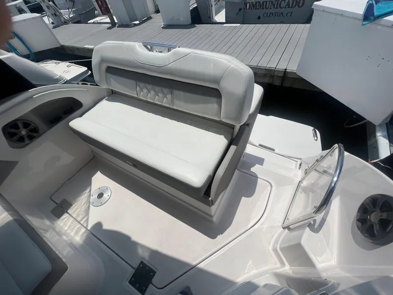 Slide: The Image of 2019 Regal 28 Express boat with white leather seating and dock background. - 18