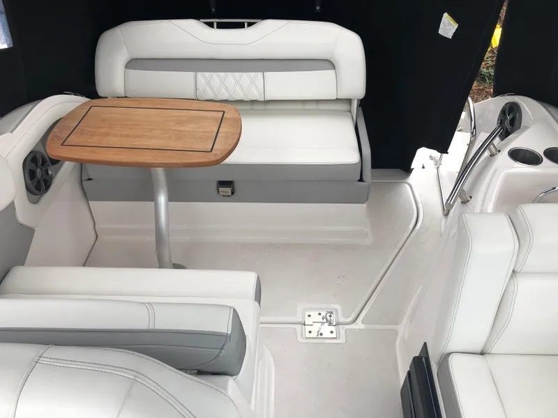 Slide: The Image of 2019 Regal 28 Express boat interior with white seating and wooden table. - 20