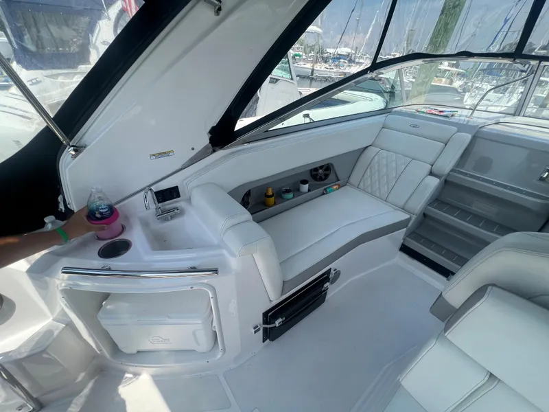 Slide: The Image of Interior of a 2019 Regal 28 Express boat with white seating and storage compartments. - 22