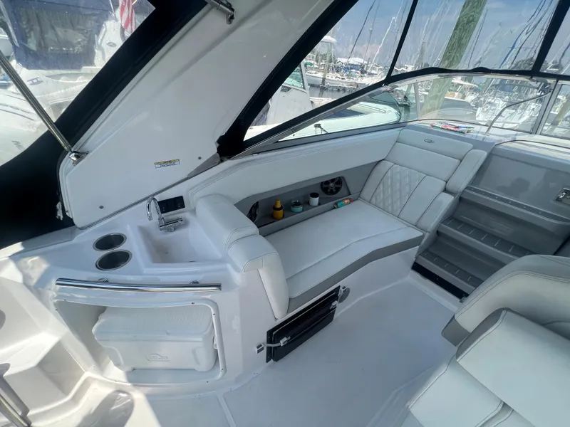 Slide: The Image of 2019 Regal 28 Express boat interior with white seating and built-in cooler. - 23