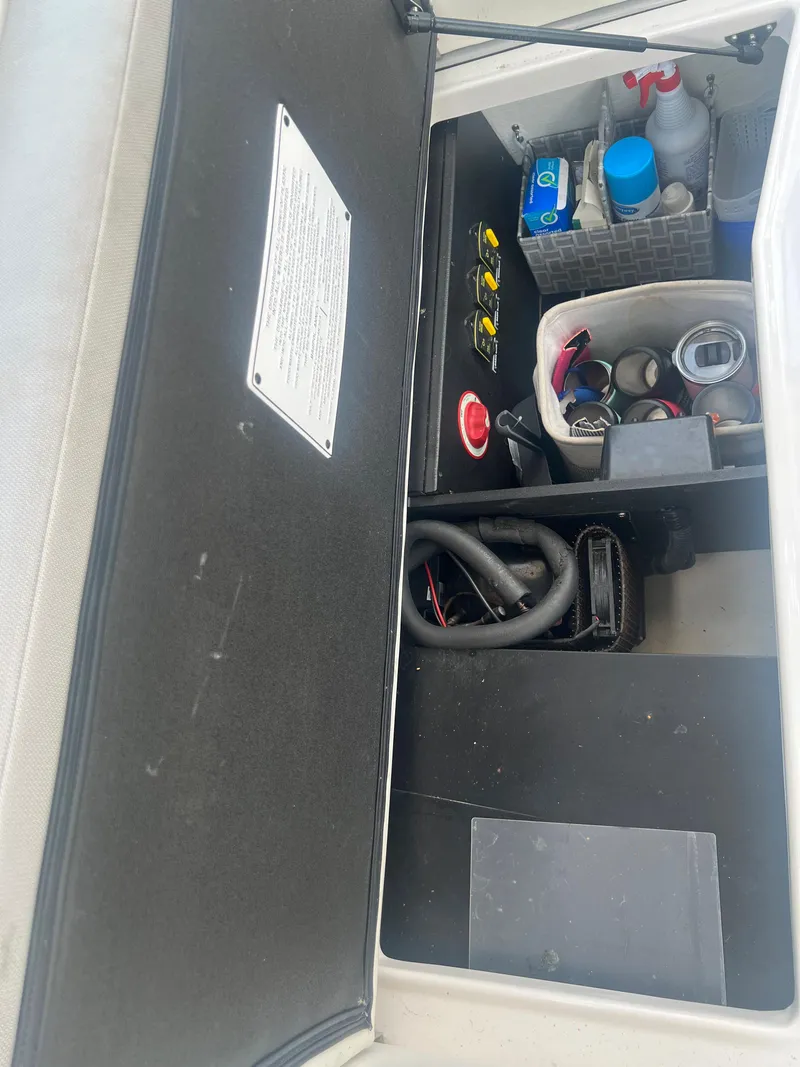 Slide: The Image of Storage compartment of a 2019 Regal 28 Express boat with various items. - 26