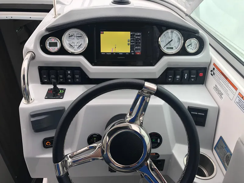 Slide: The Image of 2019 Regal 28 Express boat dashboard with steering wheel and navigation controls. - 27
