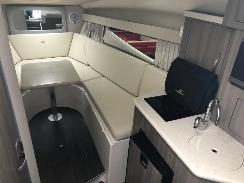 Slide: The Image of 2019 Regal 28 Express cabin interior with seating, table, and kitchenette. - 34