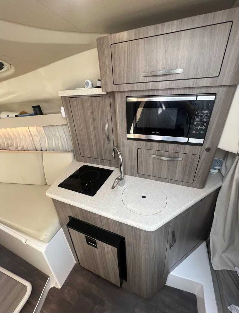 Slide: The Image of Compact kitchen area in a 2019 Regal 28 Express boat with microwave and sink. - 36