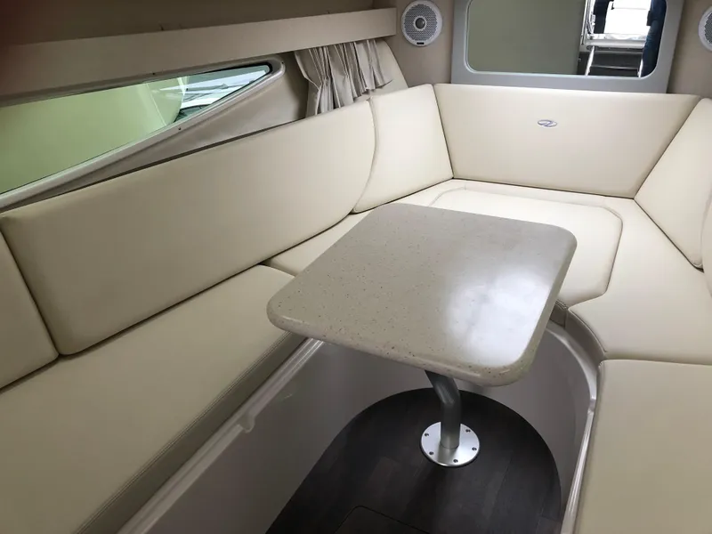 Slide: The Image of 2019 Regal 28 Express cabin interior with beige seating and table. - 38