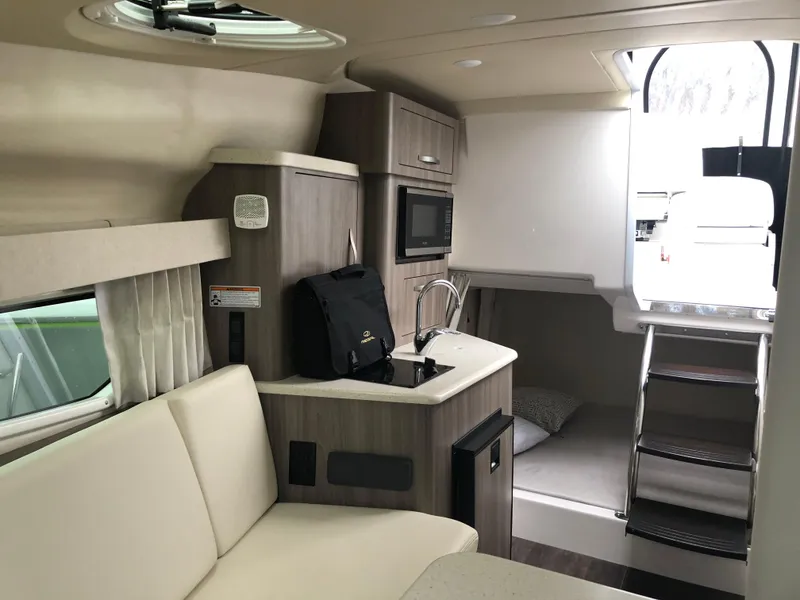 Slide: The Image of 2019 Regal 28 Express boat interior with kitchenette and seating area. - 40