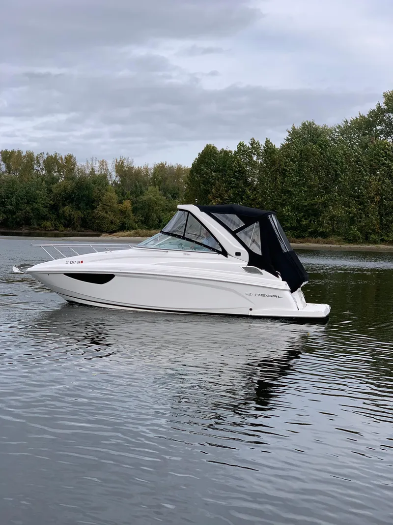 Slide: The Image of 2019 Regal 28 Express boat cruising on a calm lake. - 6
