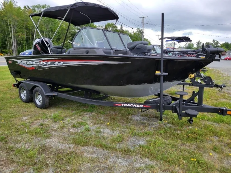 Slide: The Image of 2024 Tracker Targa V19 Combo boat on trailer, black with red accents. - 13