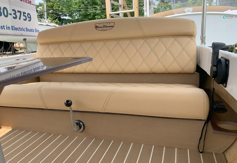 Slide: The Image of 2023 Vision Marine Technologies Quietude 156 boat interior with beige cushioned seating. - 4