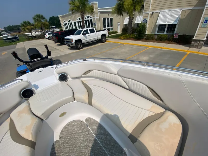 Slide: The Image of 2009 Starcraft 2410 OB Limited boat interior with white seating in a parking lot. - 17