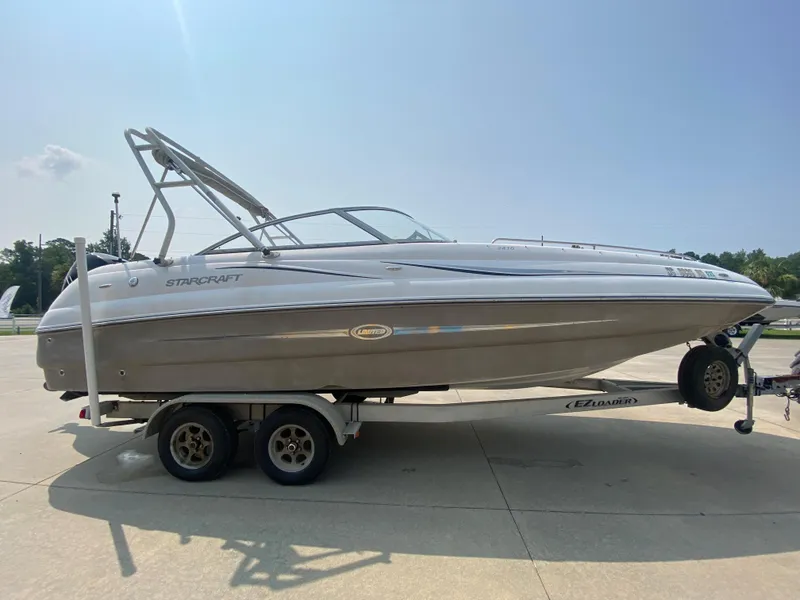 Slide: The Image of 2009 Starcraft 2410 OB Limited boat on a trailer in a parking lot. - 3