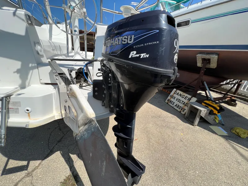 Slide: The Image of Tohatsu outboard motor on a 2007 Hunter 25 sailboat, docked in a marina. - 12