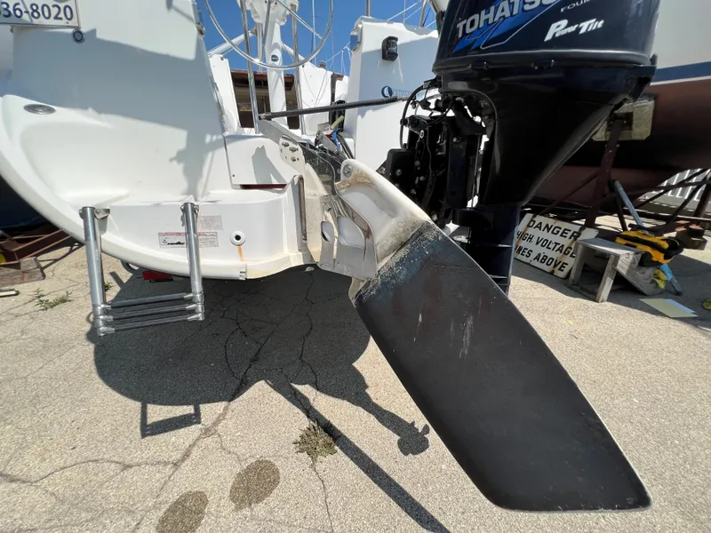 Slide: The Image of 2007 Hunter 25 sailboat with Tohatsu outboard motor, docked on concrete surface. - 14