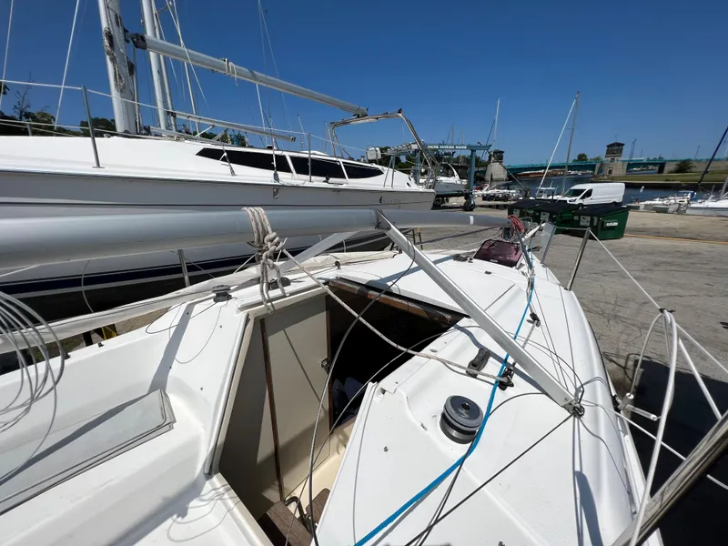 Slide: The Image of 2007 Hunter 25 sailboat docked, showing deck and rigging under clear blue sky. - 20