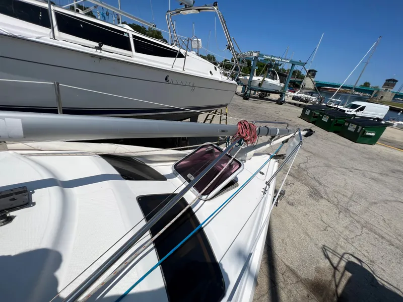 Slide: The Image of 2007 Hunter 25 sailboat on dry dock, surrounded by other boats. - 22