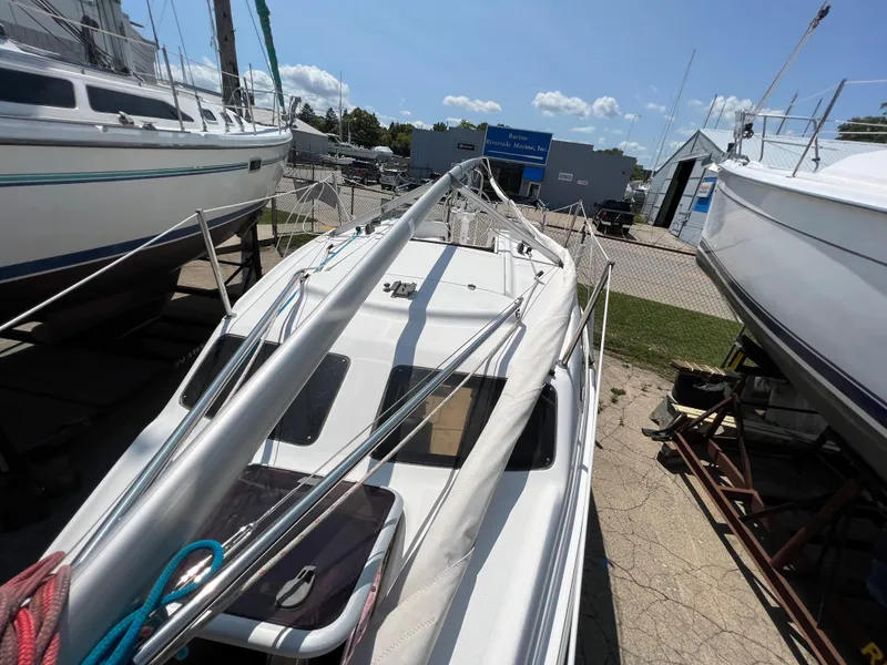 Slide: The Image of 2007 Hunter 25 sailboat on dry dock, surrounded by other boats under clear skies. - 24