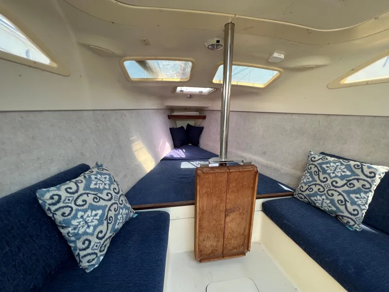 Slide: The Image of Interior of 2007 Hunter 25 sailboat with blue seating and decorative pillows. - 27