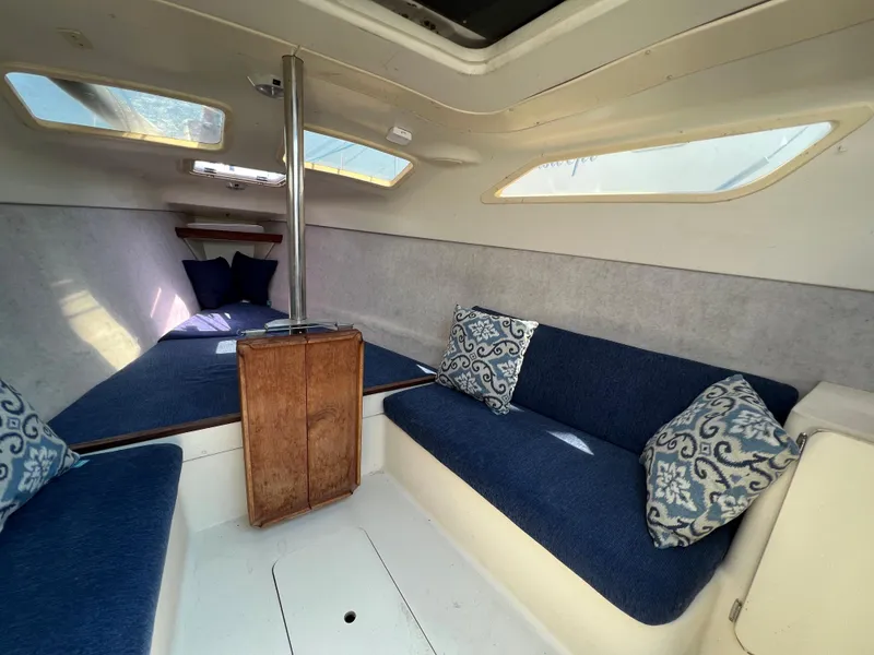 Slide: The Image of Interior of 2007 Hunter 25 sailboat with blue seating and decorative pillows. - 29