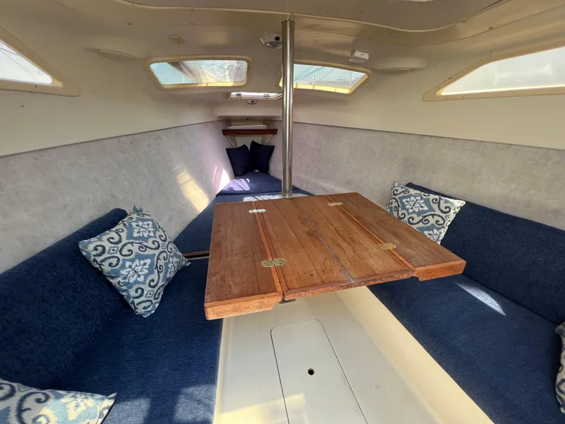 Slide: The Image of Interior of 2007 Hunter 25 sailboat with wooden table and blue seating. - 30