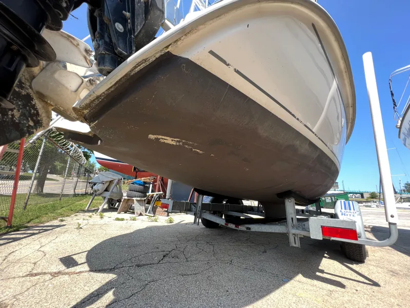 Slide: The Image of 2007 Hunter 25 boat on trailer, showing hull and motor in a sunny outdoor setting. - 7
