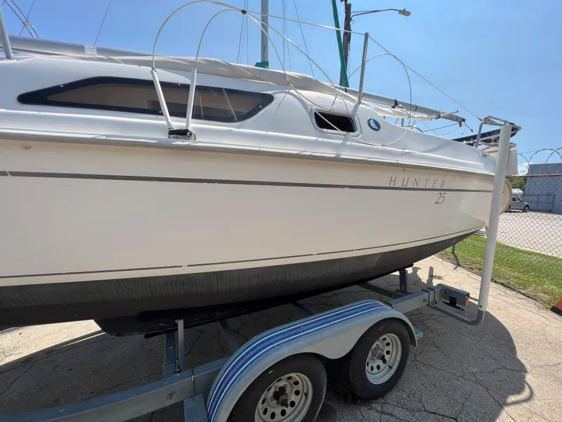 Slide: The Image of 2007 Hunter 25 sailboat on trailer, side view in outdoor setting. - 9