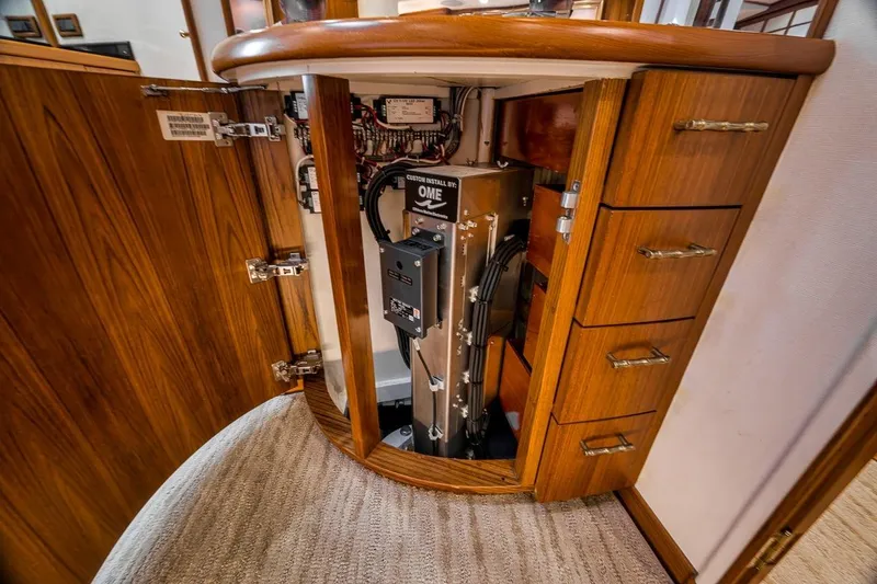 Slide: The Image of Interior view of a 2001 Rybovich Sportfisherman showcasing electrical components in a wooden cabinet. - 14