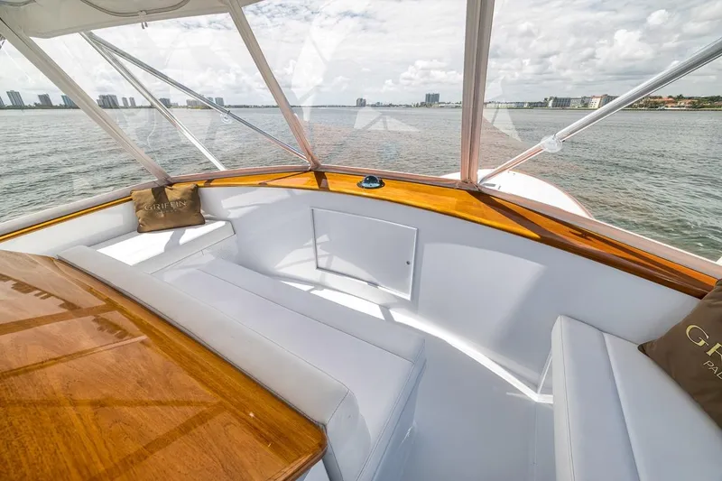 Slide: The Image of 2001 Rybovich Sportfisherman boat interior with white seating and wooden accents, overlooking the water. - 21