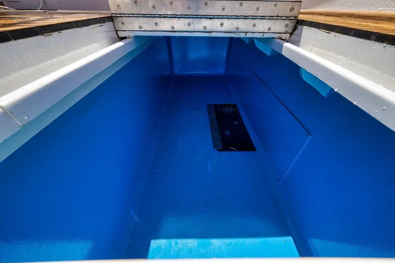 Slide: The Image of Open storage compartment on 2001 Rybovich Sportfisherman boat, featuring a bright blue interior. - 32