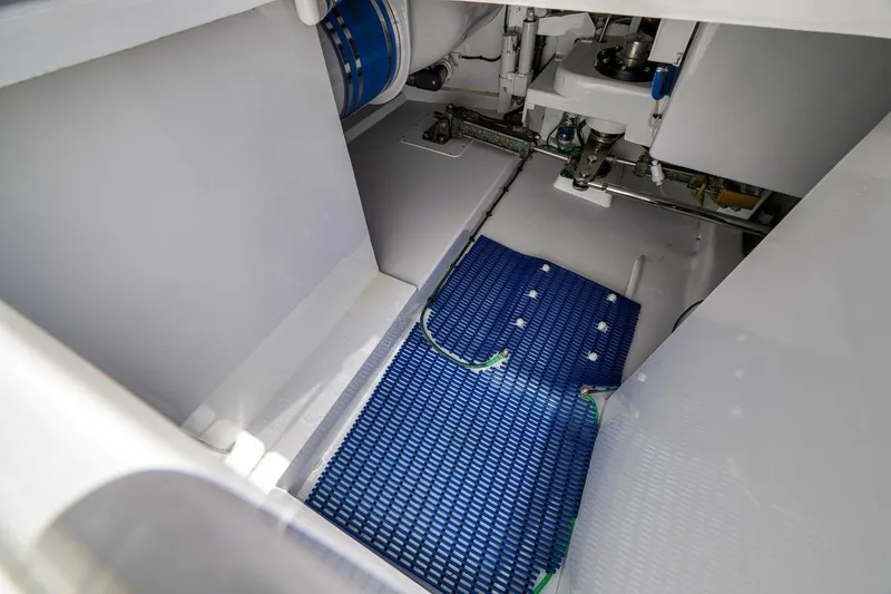 Slide: The Image of Engine room of a 2001 Rybovich Sportfisherman with blue mat and mechanical components. - 33