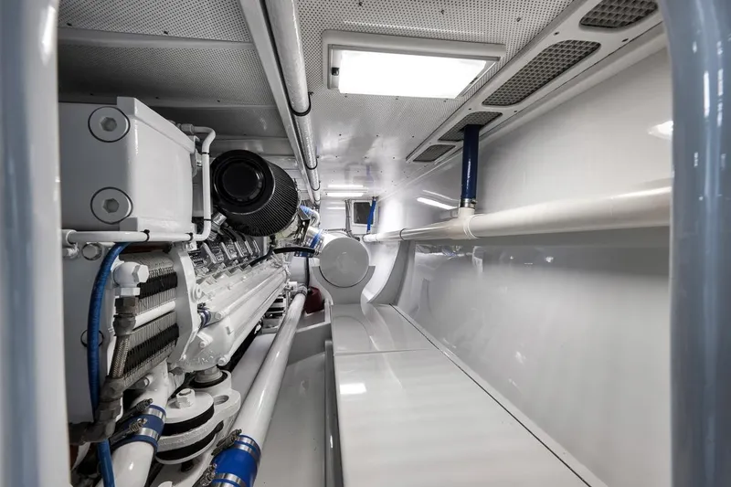 Slide: The Image of Engine room of a 2001 Rybovich Sportfisherman boat, showcasing mechanical components and piping. - 41