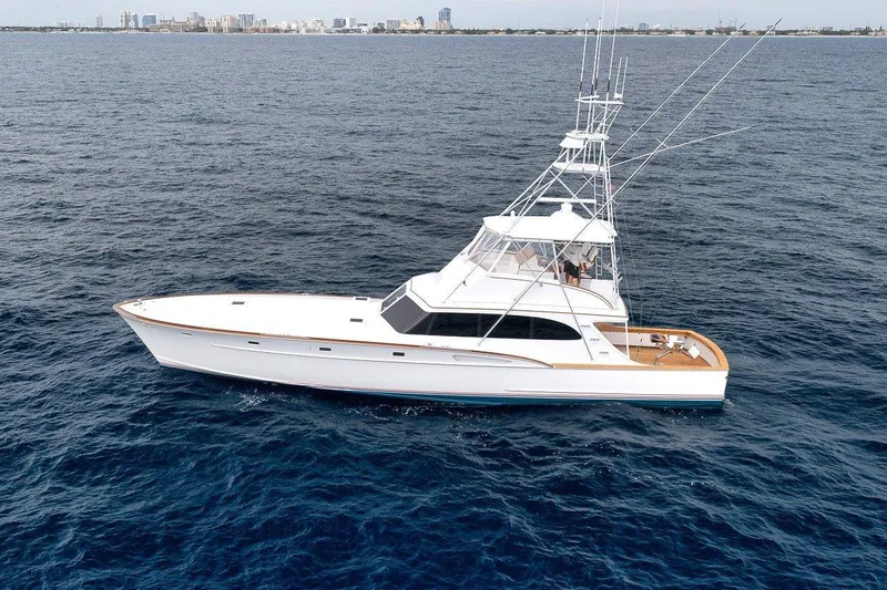 Slide: The Image of 2001 Rybovich Sportfisherman yacht cruising on open ocean with city skyline in background. - 43