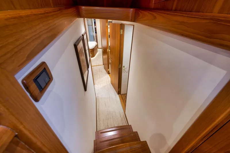 Slide: The Image of Interior view of 2001 Rybovich Sportfisherman yacht, featuring wooden stairs and hallway. - 9