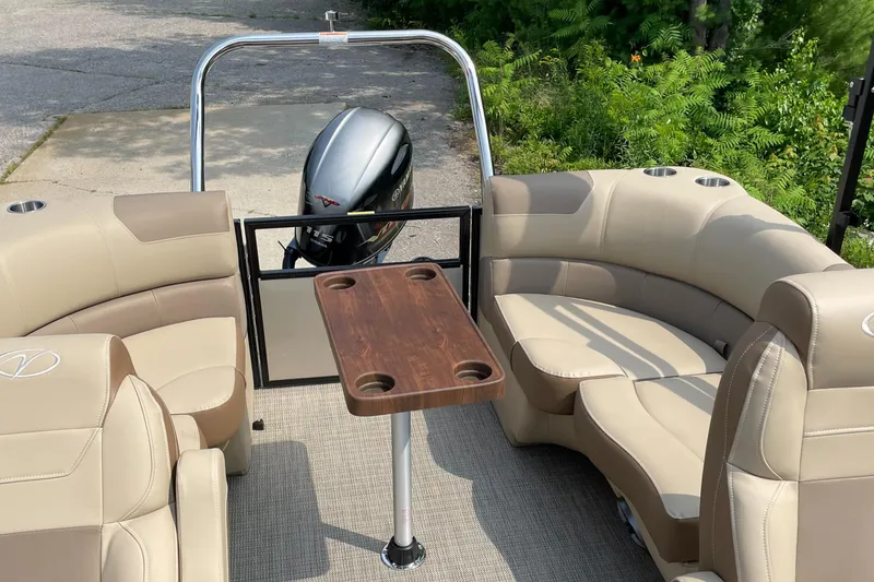 Slide: The Image of 2024 Veranda VR20RC pontoon boat interior with beige seating and wooden table. - 1